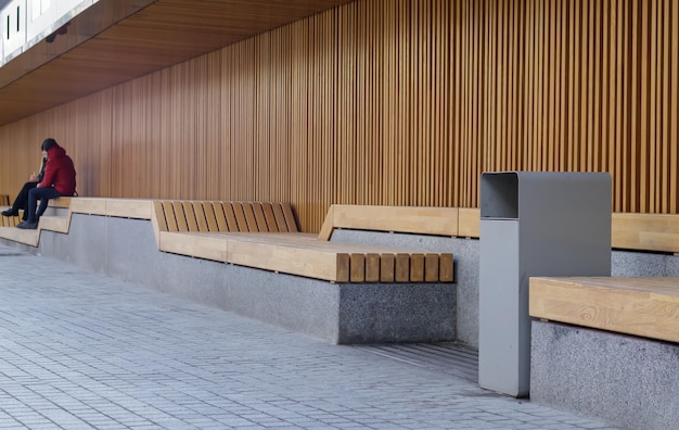 Bancos de madera modernos en un día soleado, lugares públicos en el parque de la ciudad. Mejora de la ciudad, urbanismo, espacios públicos, zona de recreo. Mobiliario público urbano antivandálico para el descanso.