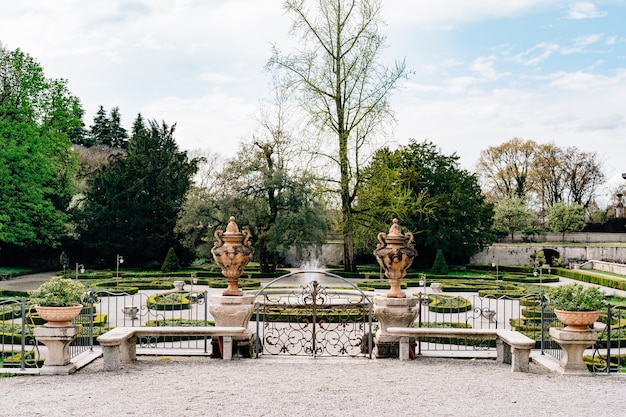 Bancos de piedra cerca de una valla metálica en el jardín de villa trivulzio italia