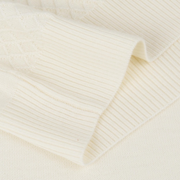 Foto banda elástica de punto sobre fondo de suéter de lana blanca cremosa de cerca