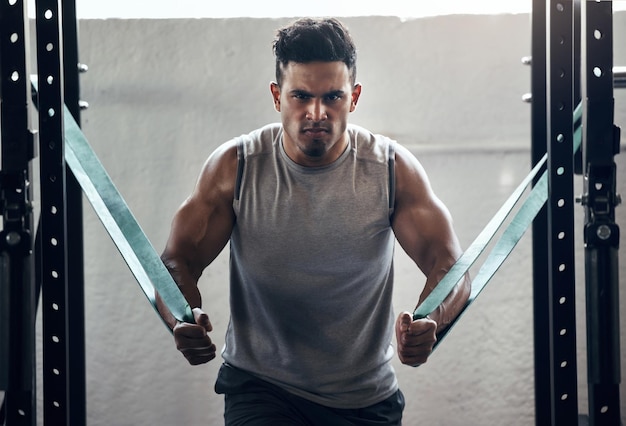 Foto banda de resistencia del hombre y culturismo en entrenamiento de gimnasia y ejercicio con bienestar de salud y fuerte motivación muscular entrenador personal de retrato o culturista en fitness con mentalidad de poder