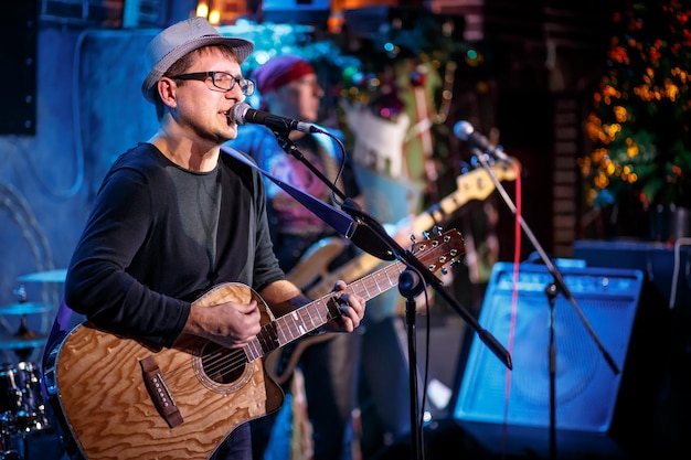 Foto banda se apresenta no palco, concerto de música rock. aviso - disparo autêntico com alto iso em condições de iluminação desafiadoras. um pouco de grão e efeitos de movimento borrado.