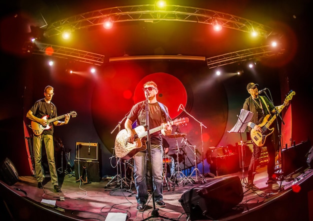 Foto banda se apresenta no palco, concerto de música rock em uma boate