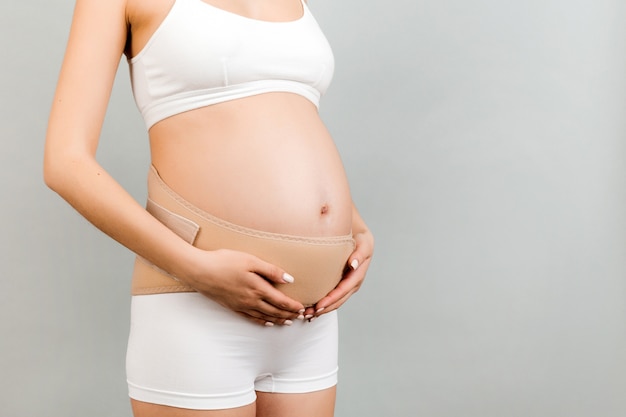 Bandagem de apoio na mulher grávida em roupa interior