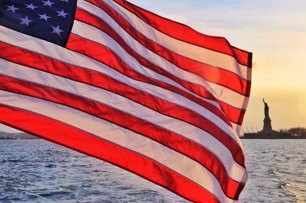 Bandeira americana contra o mar durante o pôr-do-sol