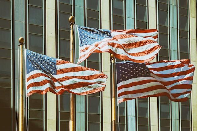 Bandeira americana que wawing na frente da construção efeitos do filtro do vintage de New York City.