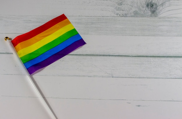 Bandeira arco-íris em uma superfície de madeira branca para a celebração do mês de história LGBT