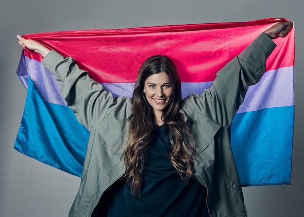 Bandeira bissexual orgulho e mulher feliz lgbtq e liberdade de amar inclusão e protesto de igualdade pelos direitos humanos Trans gay e política de identidade e comunidade em retrato no fundo do estúdio
