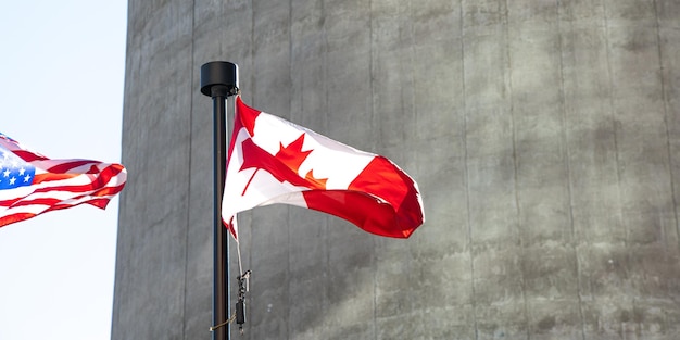 Bandeira canadense e americana voando ao vento