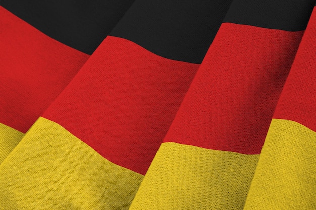 Bandeira da Alemanha com grandes dobras acenando sob a luz do estúdio dentro de casa Os símbolos e cores oficiais no banner