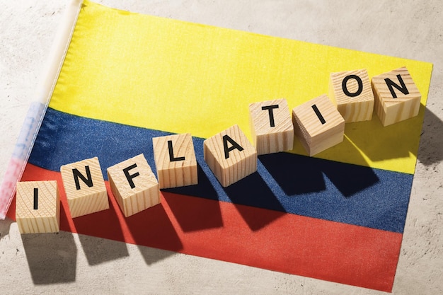 Bandeira da Colômbia e cubos de madeira com texto um conceito sobre o tema da inflação no país