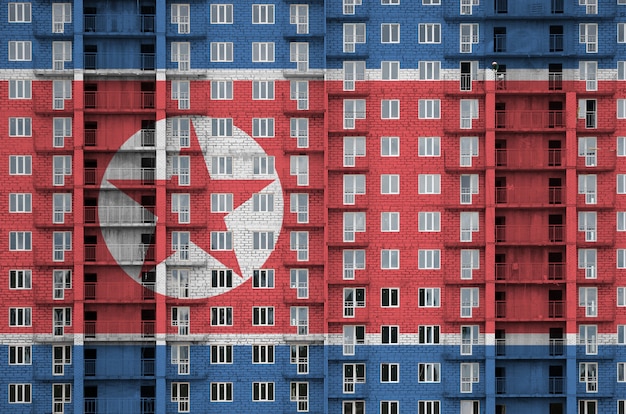 Bandeira da coreia do norte retratada em cores de tinta no edifício residencial de vários andares em construção.