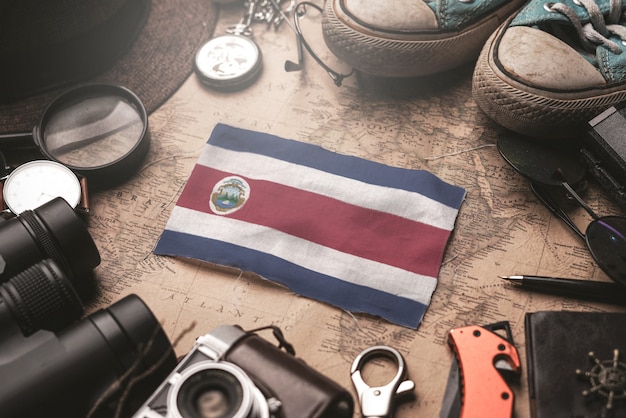 Bandeira da Costa Rica entre acessórios do viajante no antigo mapa vintage. Conceito de destino turístico.