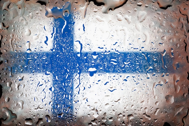 Bandeira da Finlândia Bandeira da Finlândia no fundo de gotas de água Bandeira com pingos de chuva Salpicos no vidro