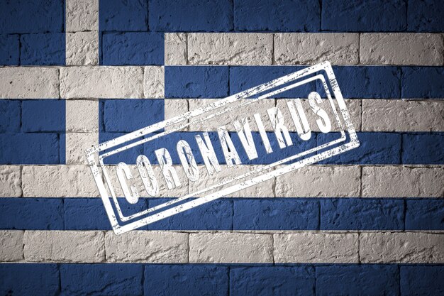 Bandeira da Grécia com proporções originais. carimbado de Coronavirus. textura da parede de tijolo. Conceito de vírus corona. À beira de uma pandemia COVID-19 ou 2019-nCoV.