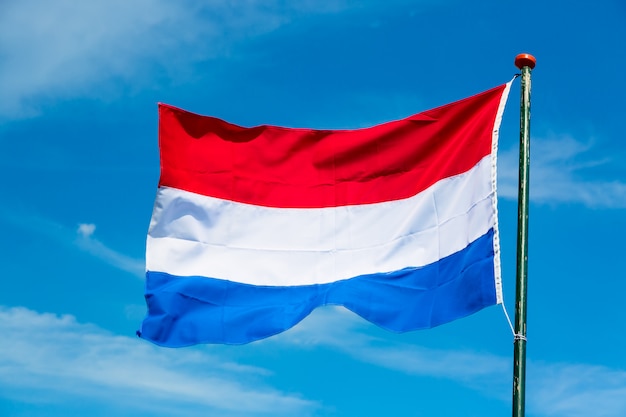 Bandeira da holanda balançando ao vento contra o céu azul