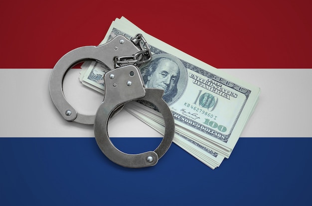 Bandeira da Holanda com algemas e um pacote de dólares. Corrupção cambial no país. Crimes financeiros