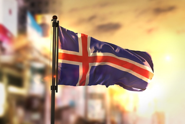 Bandeira da Islândia contra a cidade Fundo borrado no amanhecer Luz de fundo