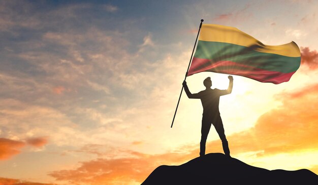 Bandeira da Lituânia sendo acenada por um homem comemorando o sucesso no topo de uma montanha 3D Rendering