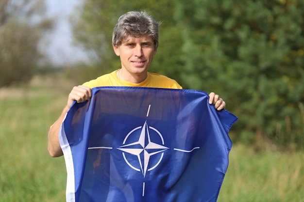 Bandeira da OTAN nas mãos de um homem