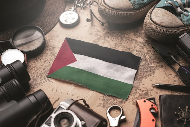 Bandeira da palestina entre acessórios do viajante no antigo mapa vintage. conceito de destino turístico.