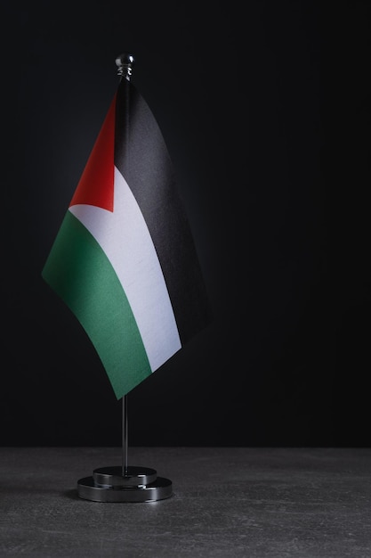 Bandeira da Palestina na mesa em suporte de metal Fundo escuro