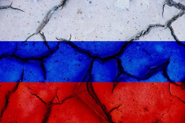 Bandeira da Rússia em solo desidratado rachado ou parede de concreto com grandes rachaduras Relações entre a Ucrânia e a Rússia Foto de alta qualidade