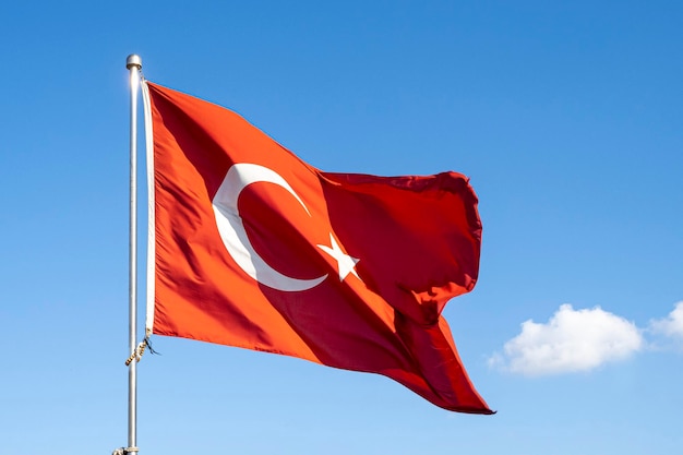 Bandeira da Turquia ou bandeira da Turquia acenando no mastro contra o céu azul em Istambul. Espaço para texto.