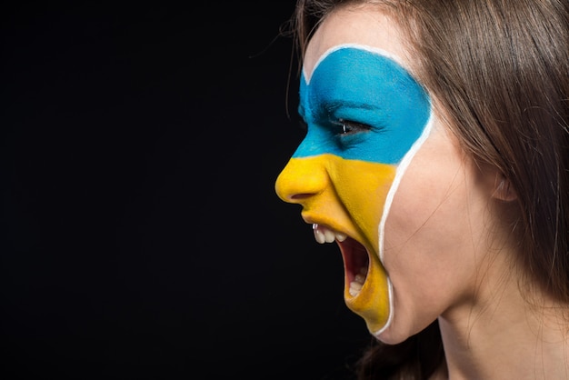 Bandeira da Ucrânia pintado na mulher de rosto.