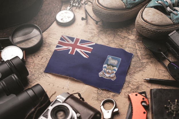 Bandeira das Ilhas Falkland entre acessórios do viajante no antigo mapa Vintage. Conceito de destino turístico.