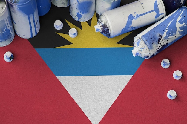 Bandeira de Antígua e Barbuda e poucas latas de aerossol usadas para pintura de grafite Conceito de cultura de arte de rua
