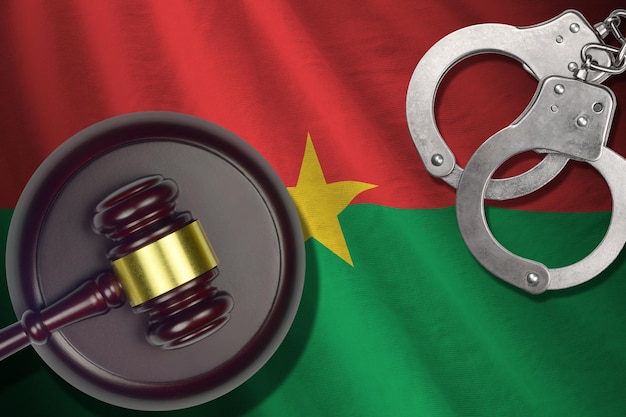 Bandeira de Burkina Faso com marreta de juiz e algemas em quarto escuro Conceito de antecedentes criminais e punitivos para tópicos de julgamento