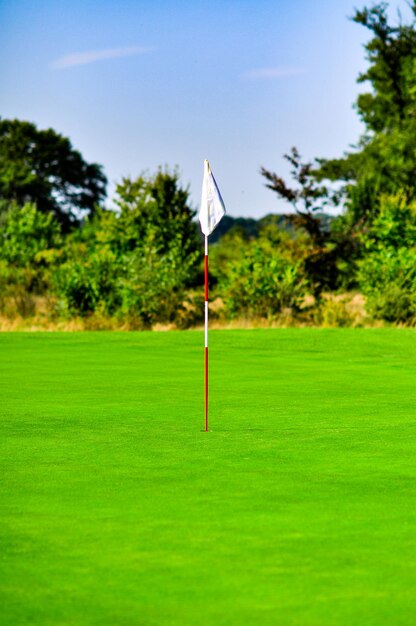 Foto bandeira de golfe em terra contra o céu