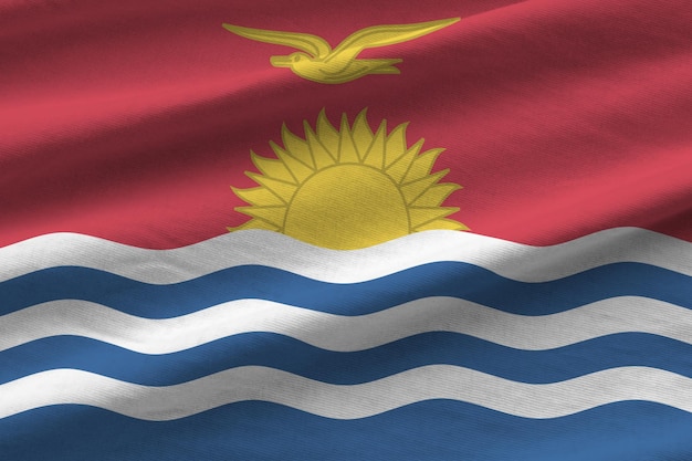 Bandeira de Kiribati com grandes dobras acenando sob a luz do estúdio dentro de casa Os símbolos oficiais e cores no banner