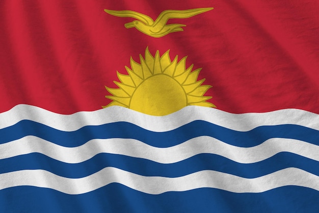 Bandeira de Kiribati com grandes dobras acenando sob a luz do estúdio dentro de casa Os símbolos oficiais e cores no banner