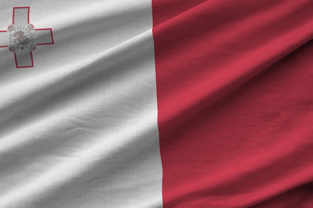 Bandeira de Malta com grandes dobras acenando de perto sob a luz do estúdio dentro de casa Os símbolos e cores oficiais no banner