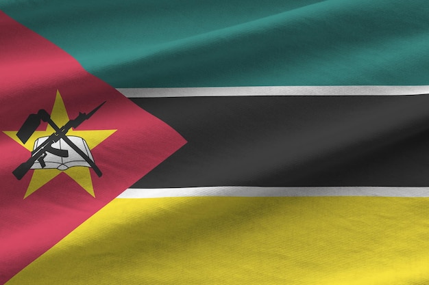 Bandeira de Moçambique com grandes dobras acenando sob a luz do estúdio dentro de casa Os símbolos oficiais e cores no banner