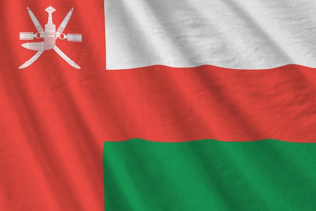 Bandeira de Omã com grandes dobras acenando sob a luz do estúdio dentro de casa Os símbolos oficiais e cores no banner