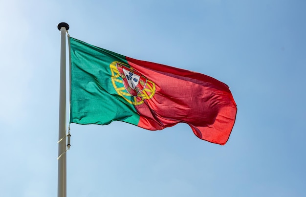 Foto bandeira de portugal acenando contra o céu azul claro
