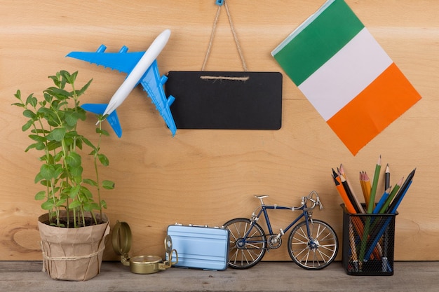 Bandeira de quadro-negro em branco do modelo de avião da irlanda, pequena bicicleta e lápis de bússola de mala