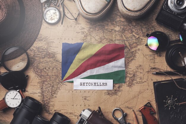 Bandeira de seychelles entre acessórios do viajante no mapa antigo do vintage. tiro aéreo