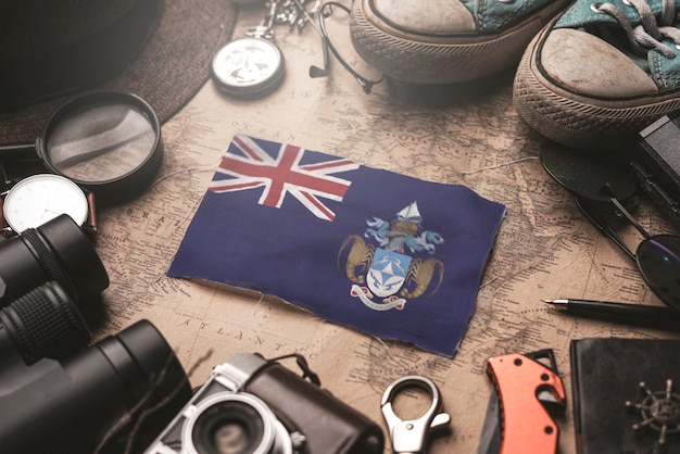 Bandeira de Tristan da Cunha entre acessórios do viajante no antigo mapa Vintage. Conceito de destino turístico.