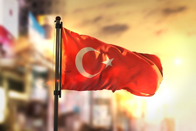 Bandeira de Turquia contra a cidade Fundo borrado no amanhecer Luz de fundo