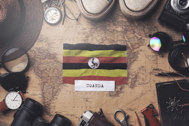 Bandeira de uganda entre acessórios do viajante no mapa antigo do vintage. tiro aéreo