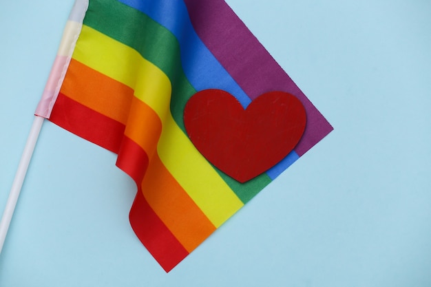 Bandeira do arco-íris LGBT e coração vermelho sobre fundo azul. O amor não tem gênero. Tolerância, liberdade