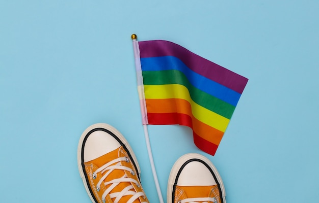 Bandeira do arco-íris lgbt e tênis sobre fundo azul. tolerância, liberdade, parada gay