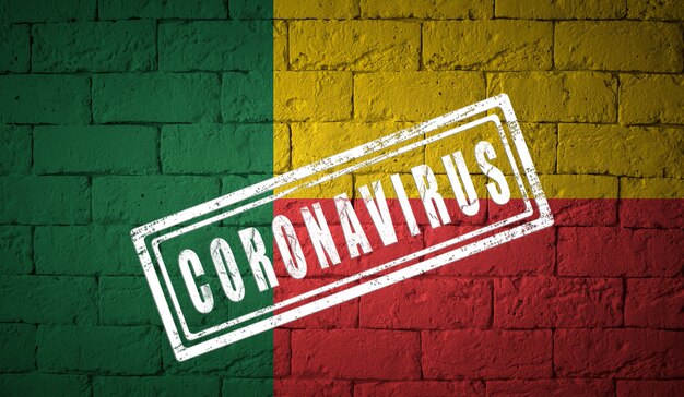 Bandeira do Benin na textura da parede de tijolos com o conceito do vírus Coronavirus Corona