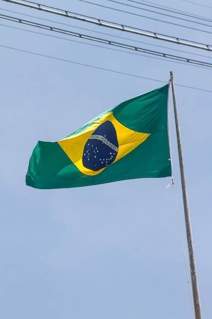 Foto bandeira do brasil ao ar livre com lindo céu azul ao fundo no rio de janeiro.