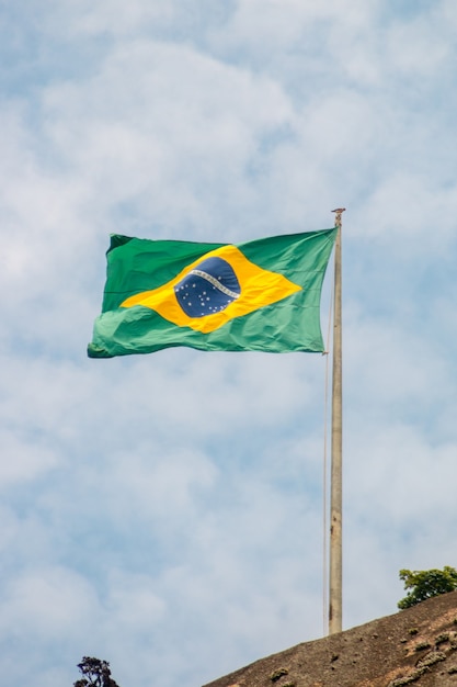Foto bandeira do brasil ao ar livre com um lindo céu azul no rio de janeiro.