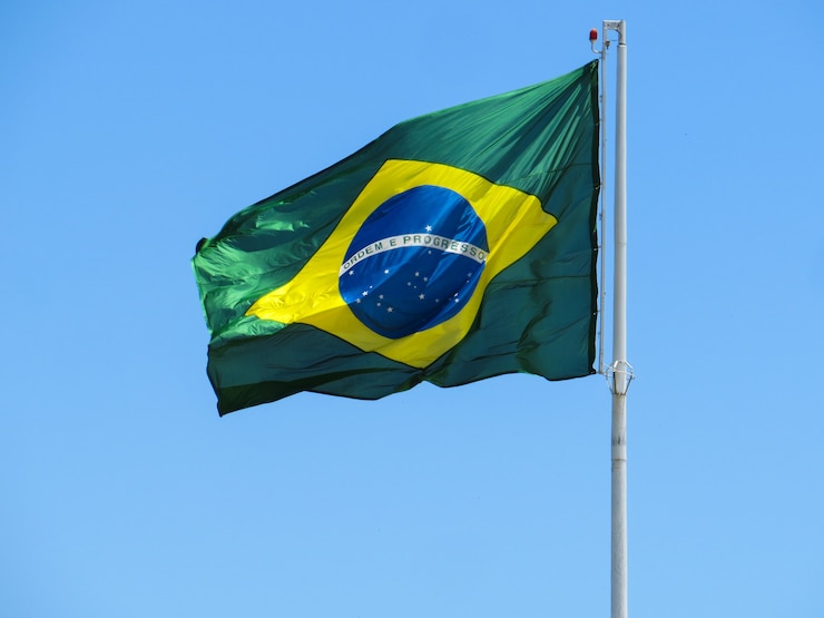 Foto bandeira do brasil tremulando ao vento. no centro da bandeira com as palavras ordem e progresso