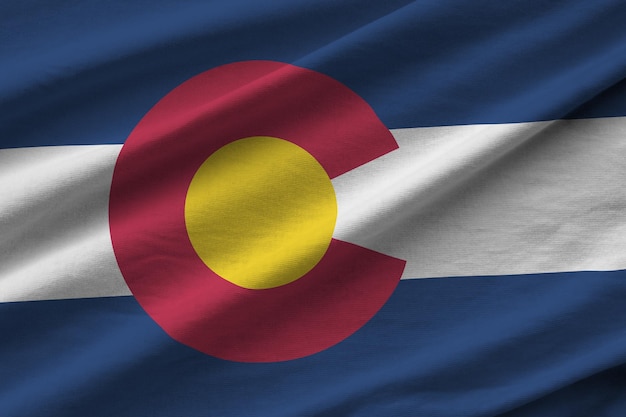 Bandeira do estado americano do Colorado com grandes dobras acenando sob a luz do estúdio dentro de casa Os símbolos e cores oficiais no banner